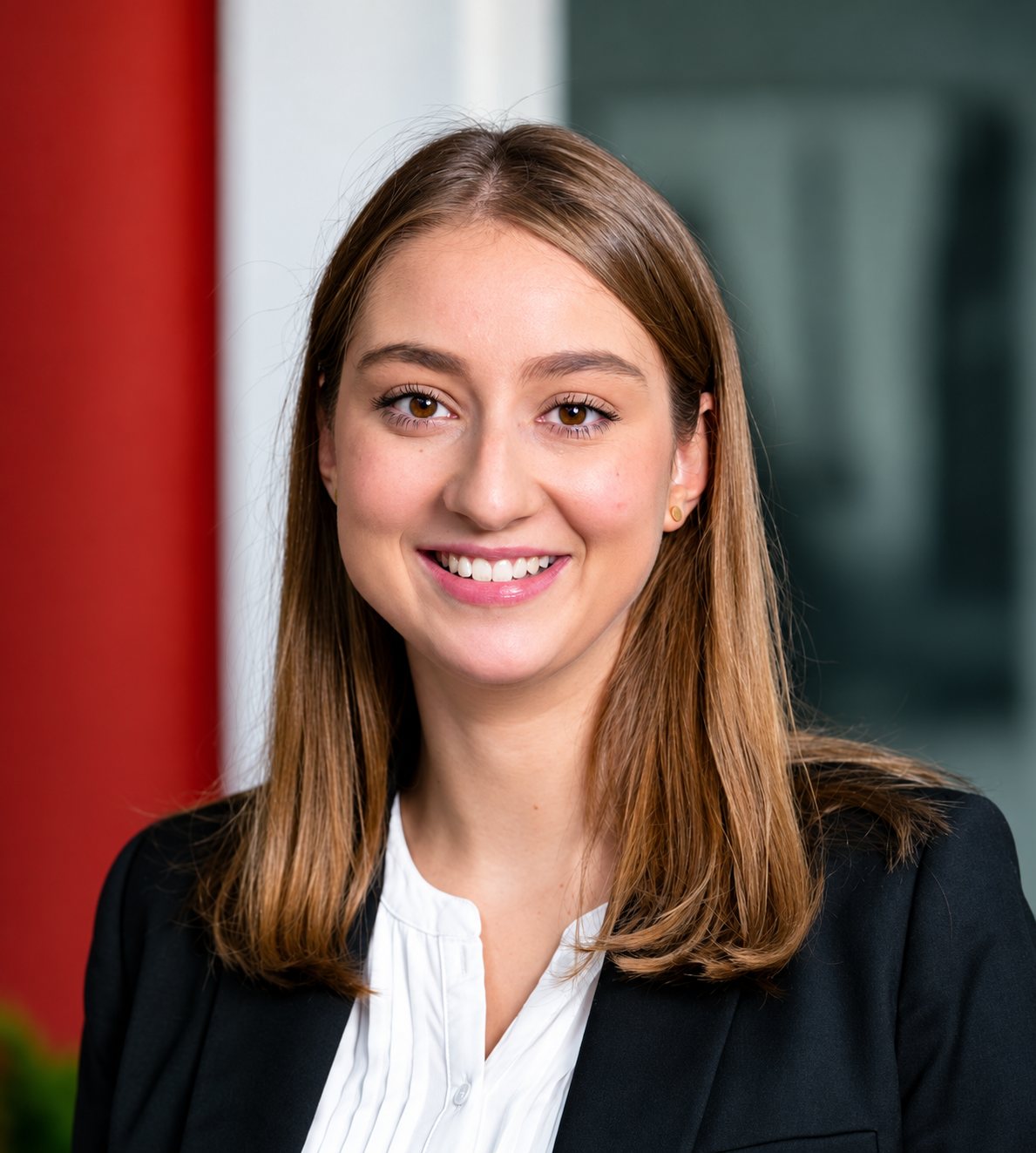 Portrait de Maëlis Jerphagnon, souriante, cheveux longs châtains, blazer noir.