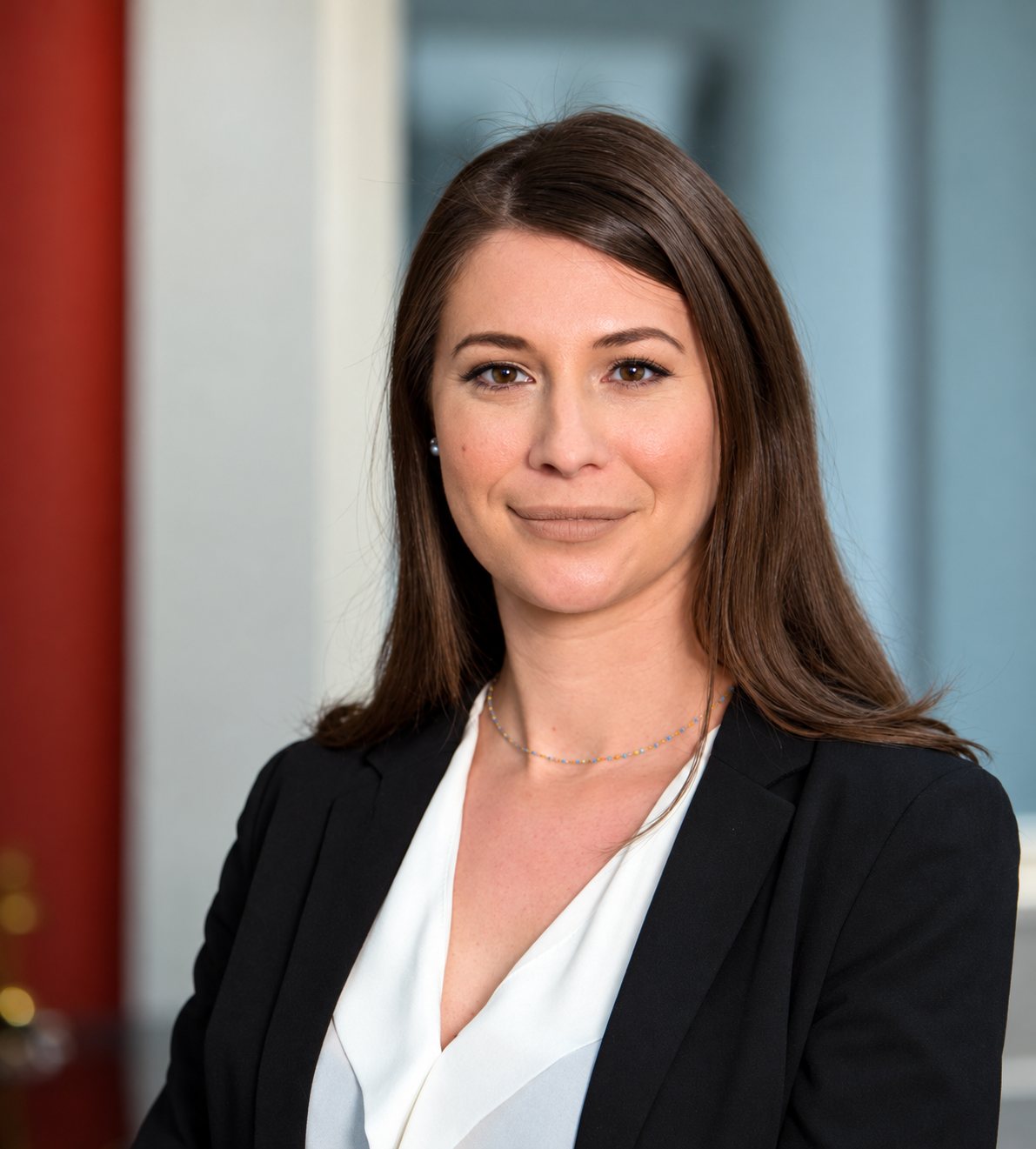 Portrait de Fabienne Jacquier, souriante, cheveux longs châtains, blazer noir.